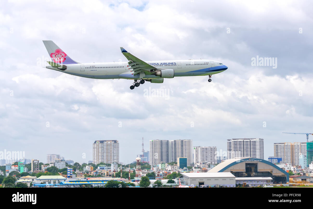 Los aviones de pasajeros Airbus A330 de China Airlines vuela sobre zonas urbanas se preparan para aterrizar en el aeropuerto internacional de Tan Son Nhat Foto de stock