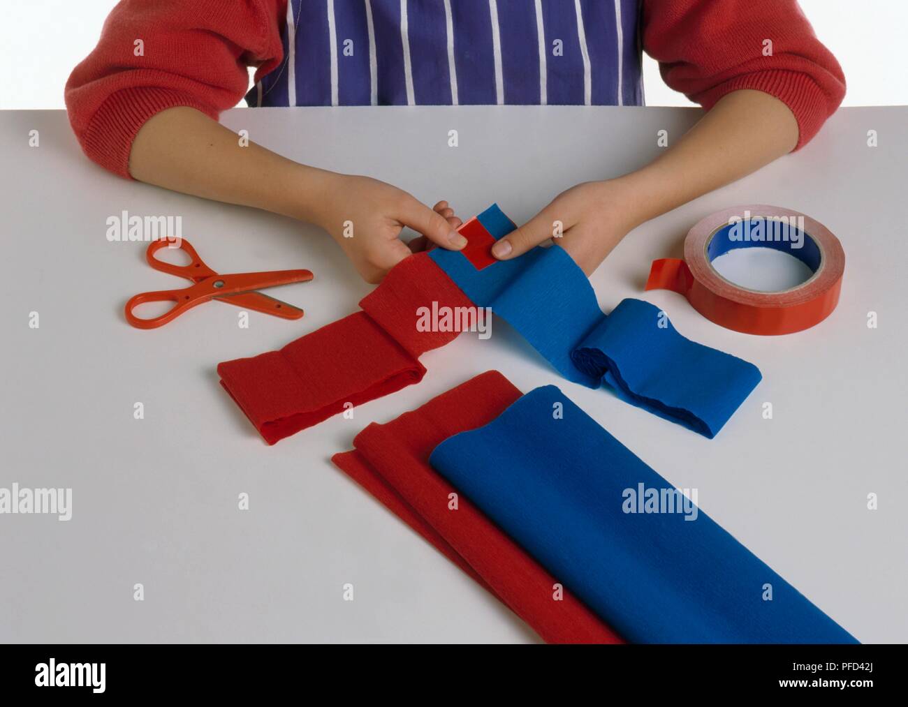 Chica manos taping tiras de papel crepé juntos, haciendo que la cadena de  papel Fotografía de stock - Alamy