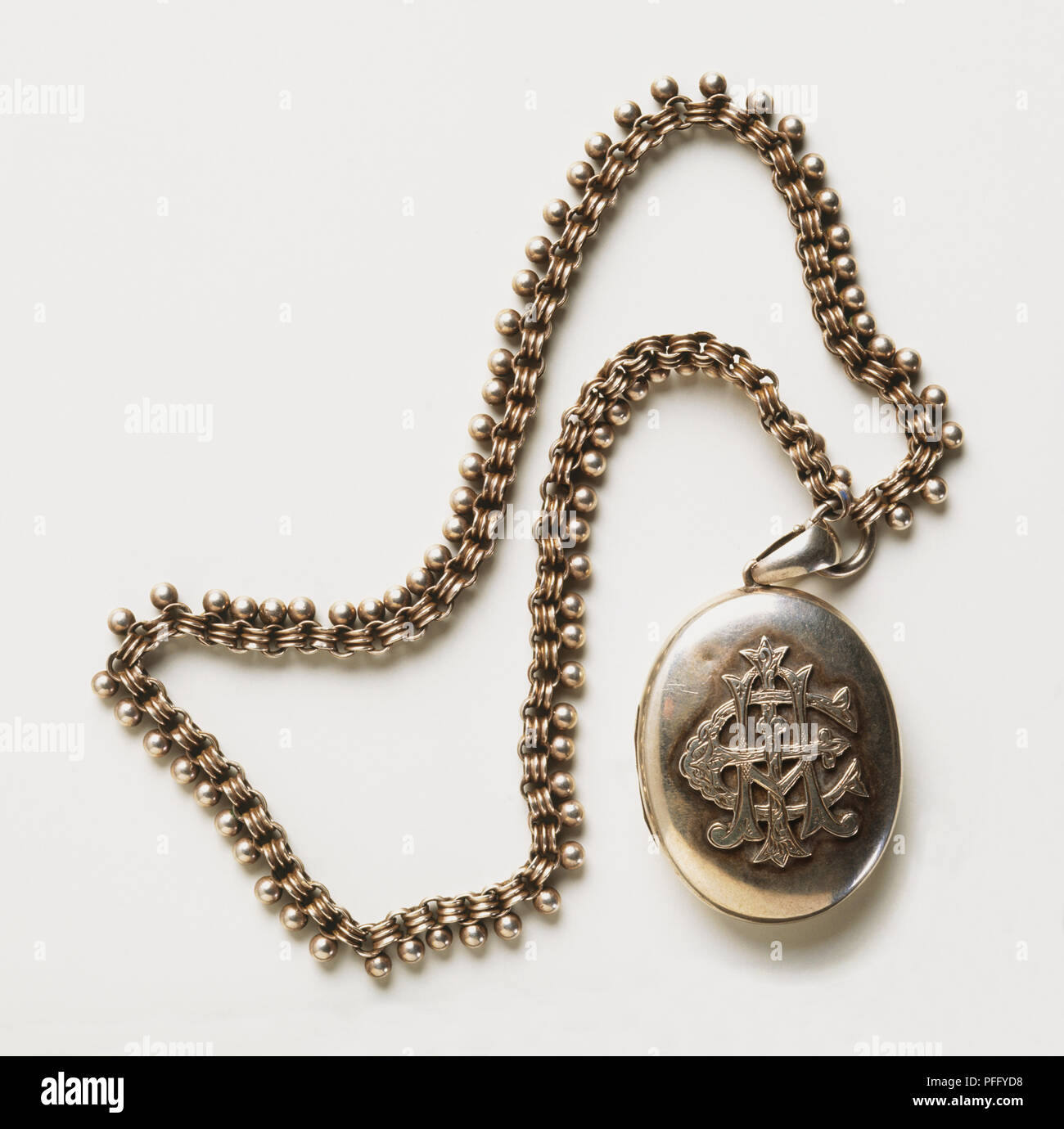 Medallón colgante de plata grabada en un collar, adornado de cerca. Foto de stock