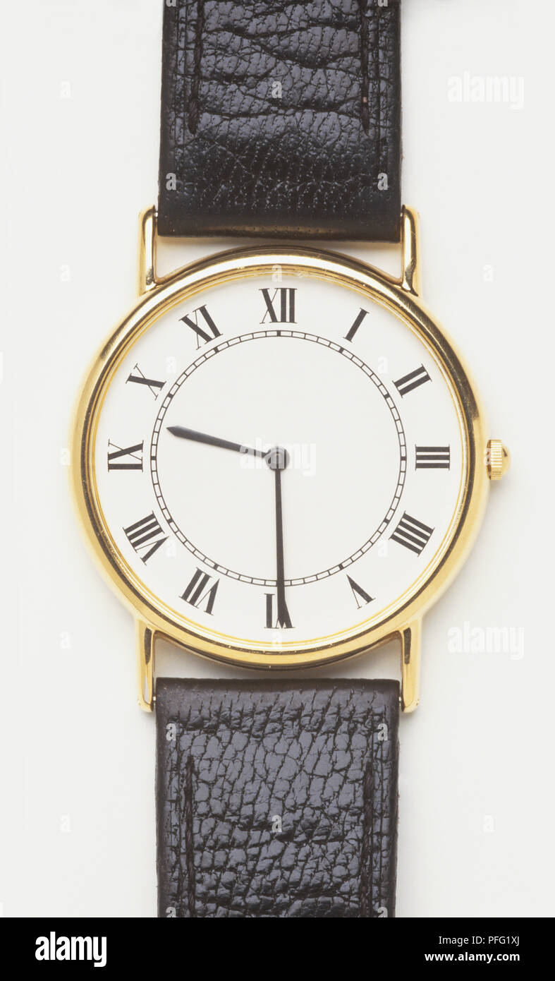 sombra Adaptabilidad interior Reloj de pulsera con la cara blanca, llanta de oro y correa de piel,  mostrando números romanos Fotografía de stock - Alamy