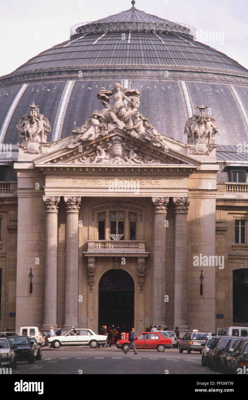 Francia, Paris, Bourse du Commerce, un gran edificio abovedado con arcos de entrada estatua tallada de entrada de piedra. Foto de stock