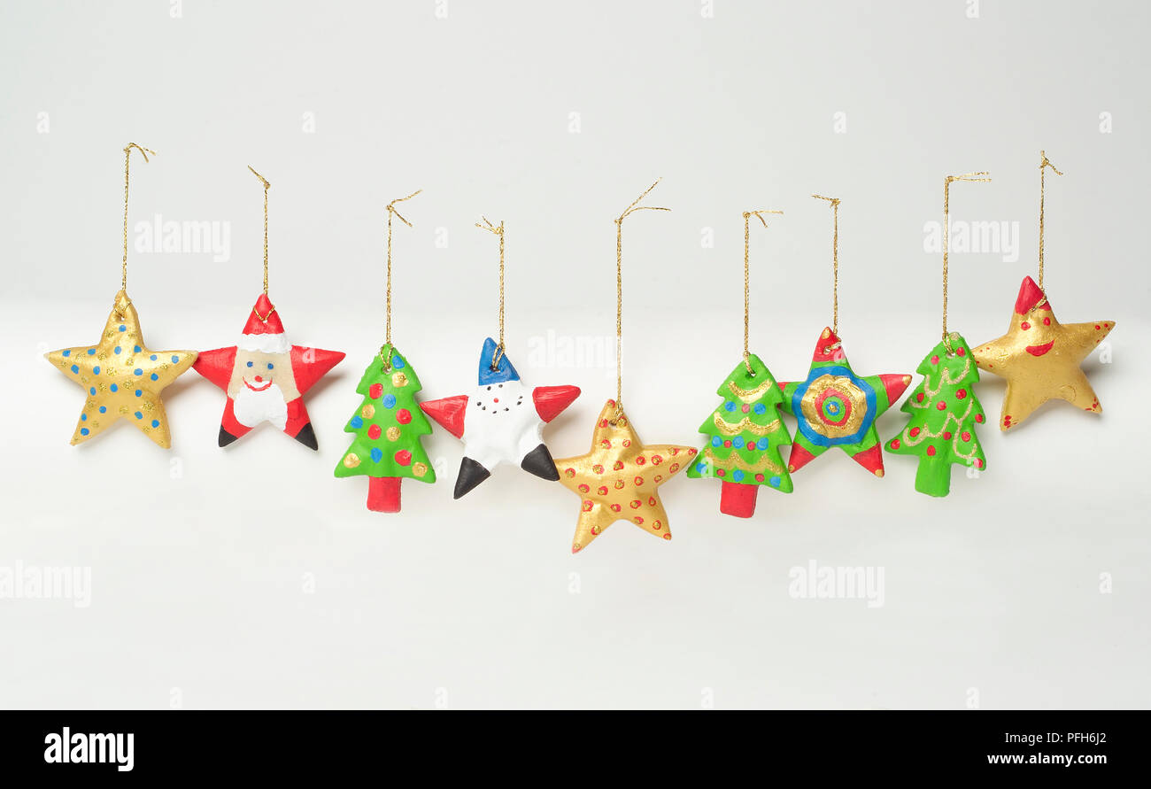 Adornos Navideños caseros, incluyendo formas de estrella y árbol de Navidad,  colgando de hilos de oro Fotografía de stock - Alamy