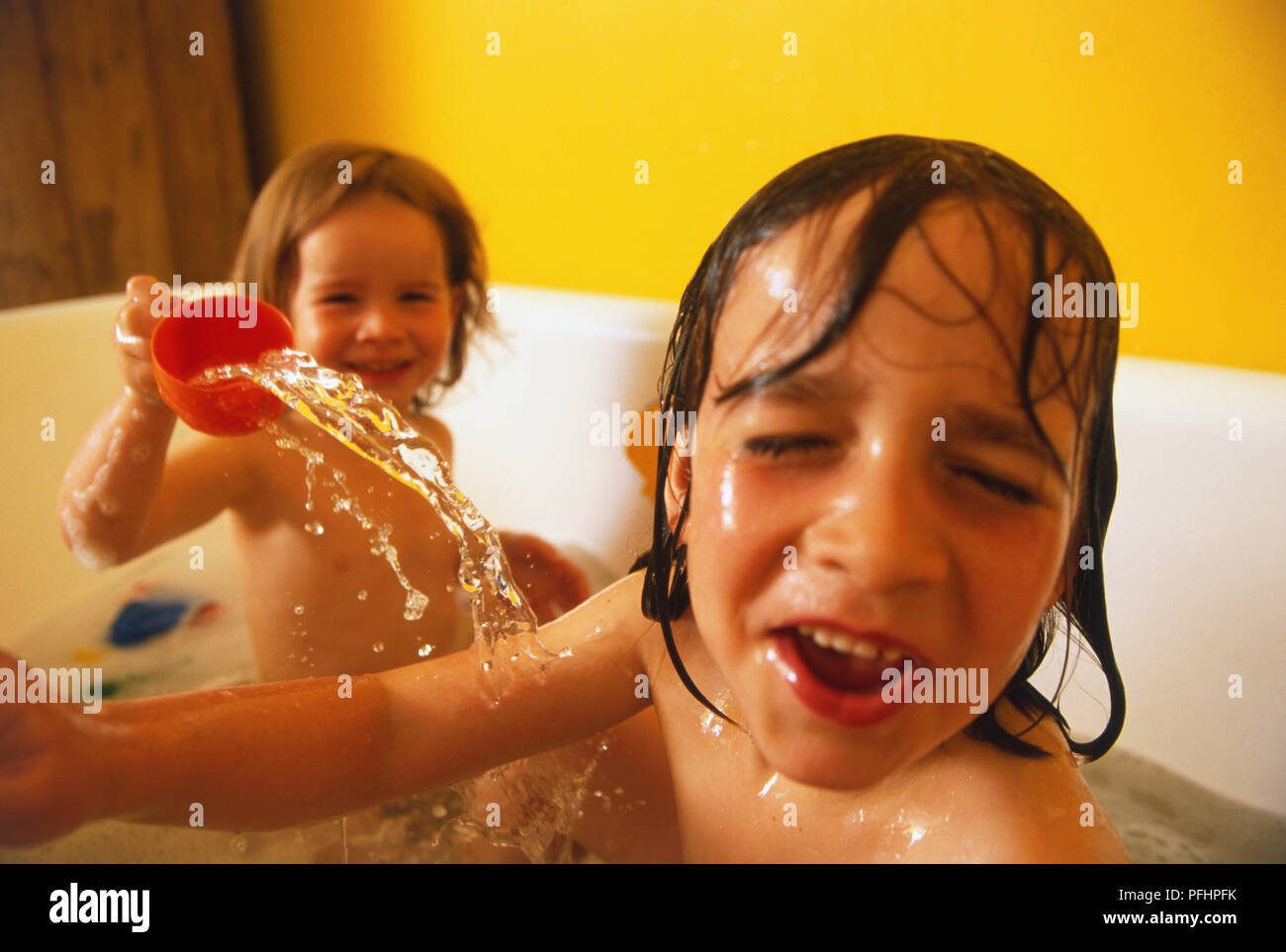 Física Bourgeon Derivar Dos niñas en el baño, uno arrojando agua a los demás Fotografía de stock -  Alamy