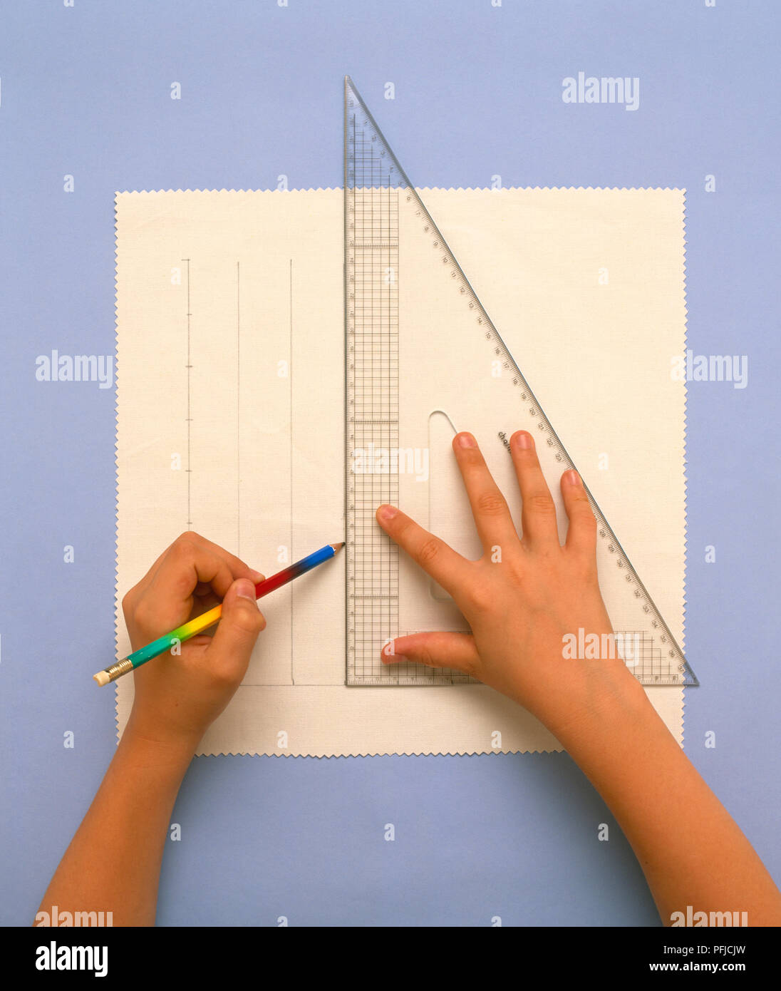 El niño utilizando lápiz y escuadra de plástico para dibujar líneas rectas  paralelas sobre tela blanca Fotografía de stock - Alamy