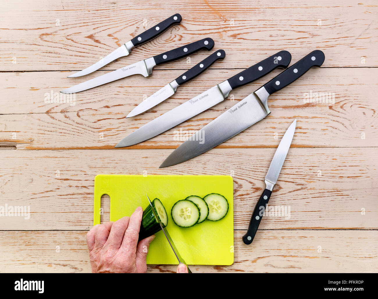 Un surtido de varios cuchillos de cocina sobre un fondo de madera. Foto de stock