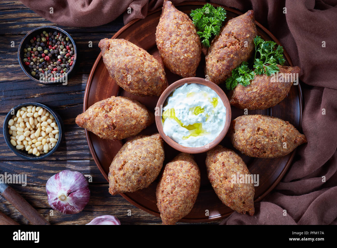 Kibbeh frito con carne molida de res, la carne mezclada con bulgur,  rellenos con carne picada frita con piñones, especias, ajo y hierbas en una  placa de arcilla en un Fotografía de