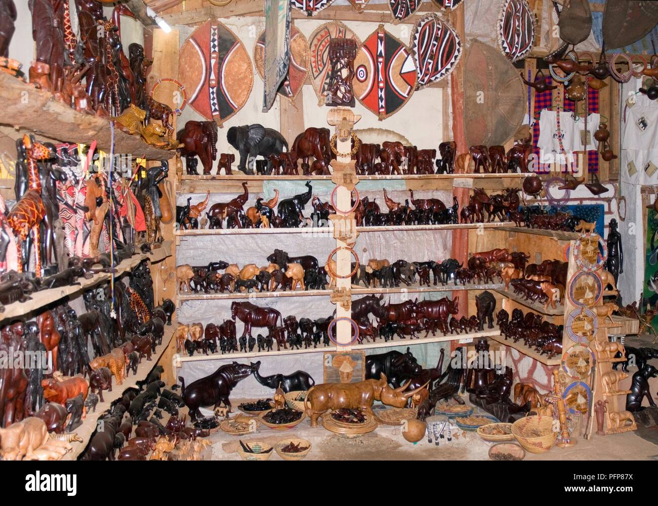 Kenya, del Valle del Rift, Namanga, interior de una tienda de souvenirs con estantes de tallas de madera Foto de stock