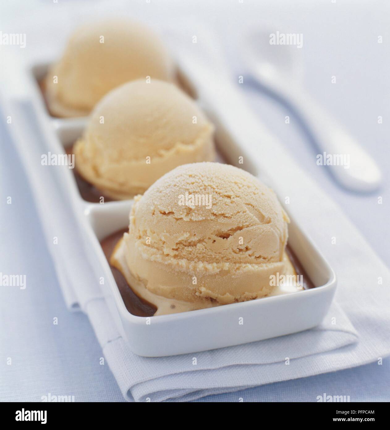 Cucharadas de helado de caramelo en divide el plato, más cerca Foto de stock