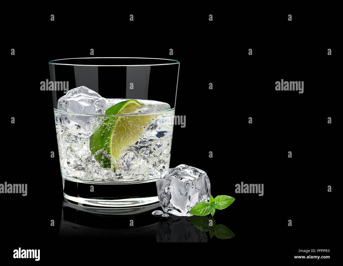 Gin Tonic o vodka limón y albahaca aislado sobre fondo negro Foto de stock