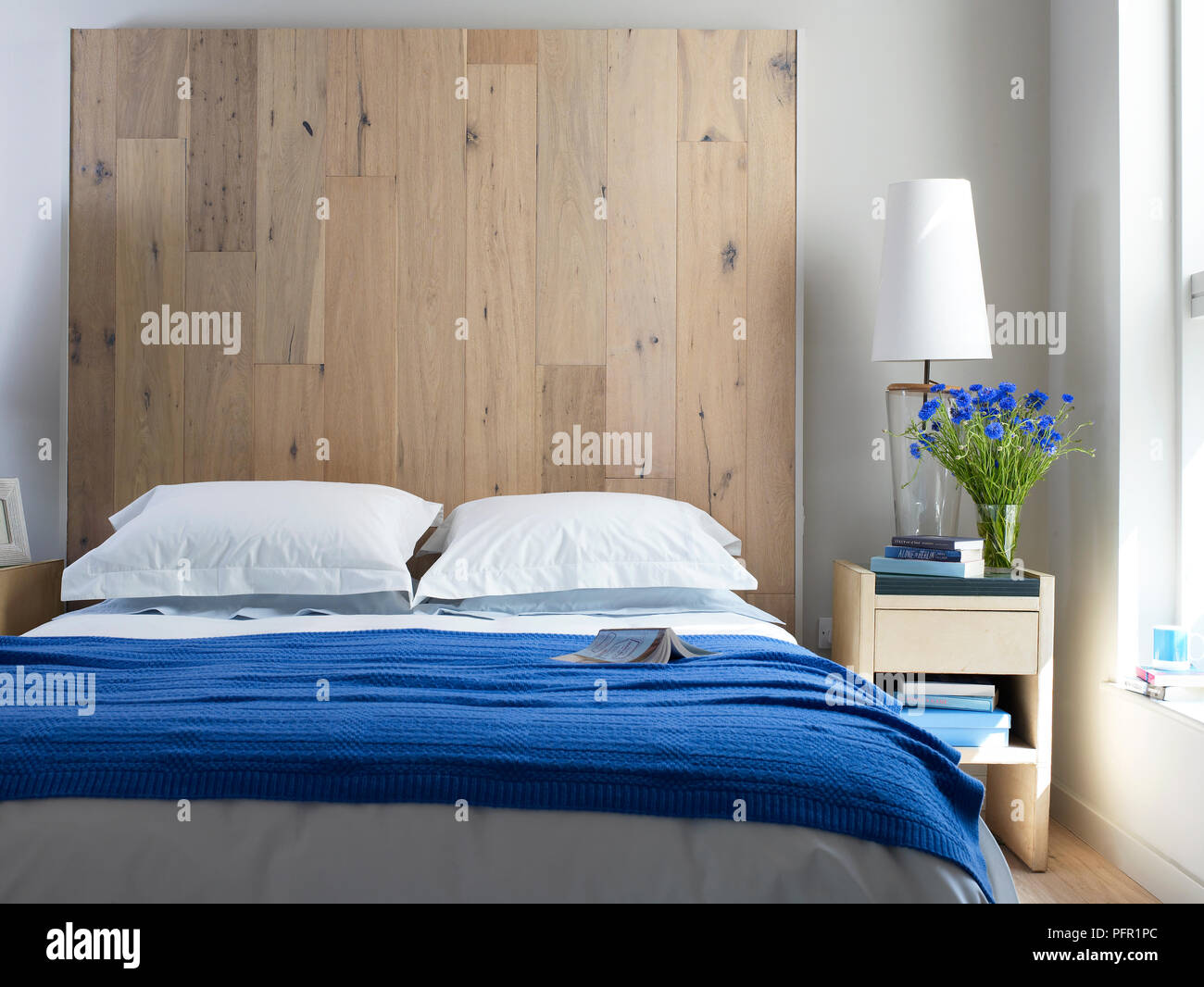 Cojines en blanco grande cama antigua con detalles tallados en dormitorio  con empapelado y mesillas de noche Fotografía de stock - Alamy