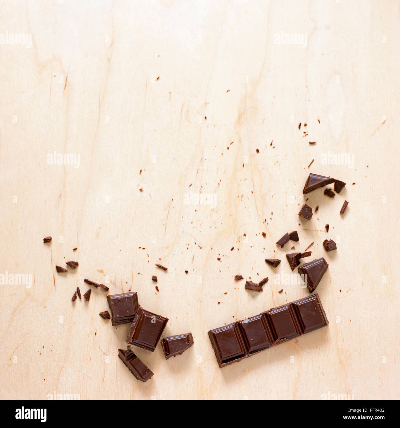 Rota en pedazos de chocolate sobre la superficie de madera Foto de stock
