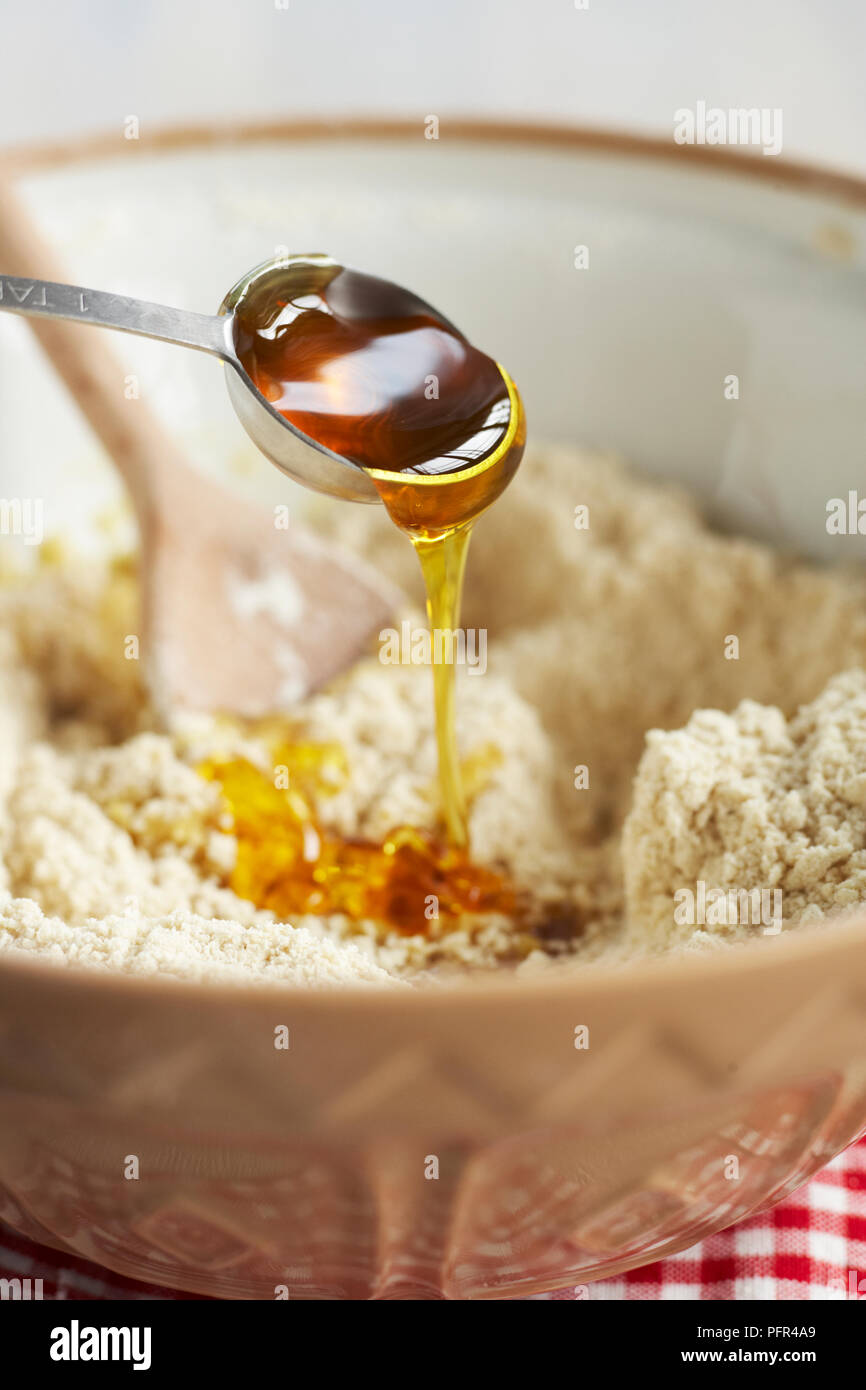 Hacer galletas de jengibre, la adición de jarabe para mezcla Foto de stock