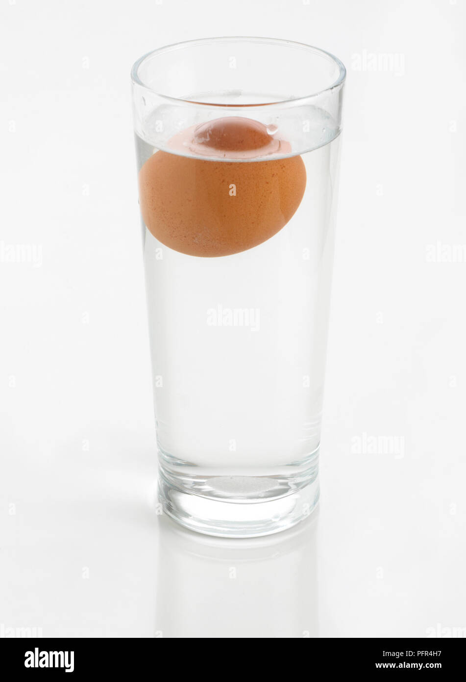 Huevo flotando en el vaso de agua (fregadero o flotar el huevo frescura  prueba Fotografía de stock - Alamy