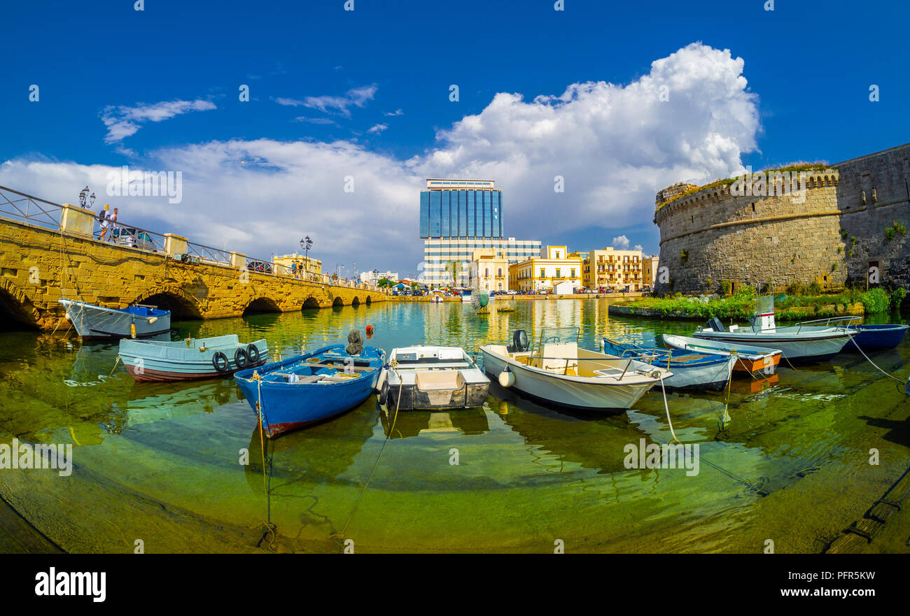 Antiguo puerto de Gallipoli, vista al paisaje urbano con el castillo y los barcos entre puente Stari Grad en Puglia, Italia Foto de stock