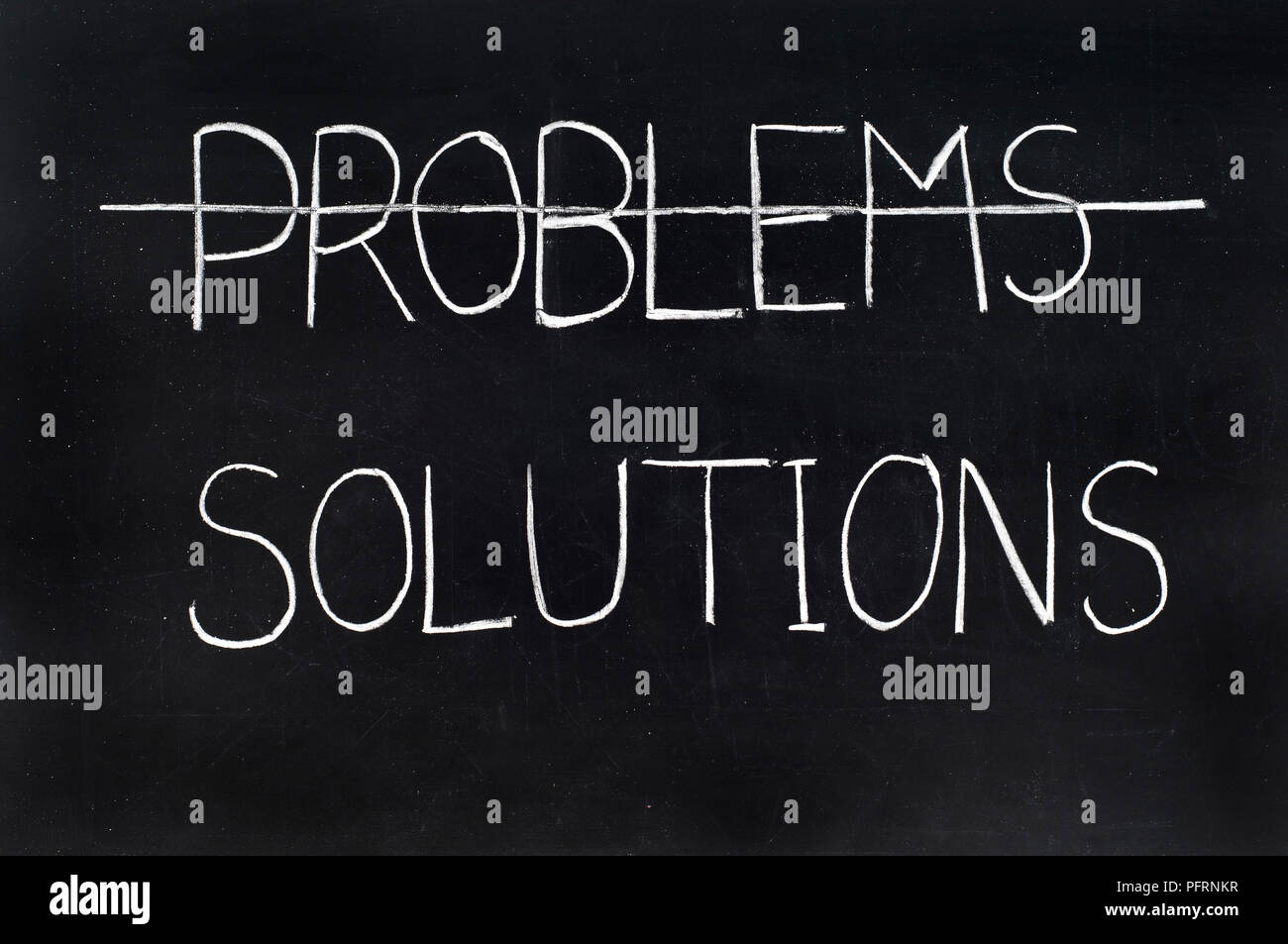 Pizarra con las palabras 'problemas' tachado y debajo de ella la palabra "soluciones" Foto de stock
