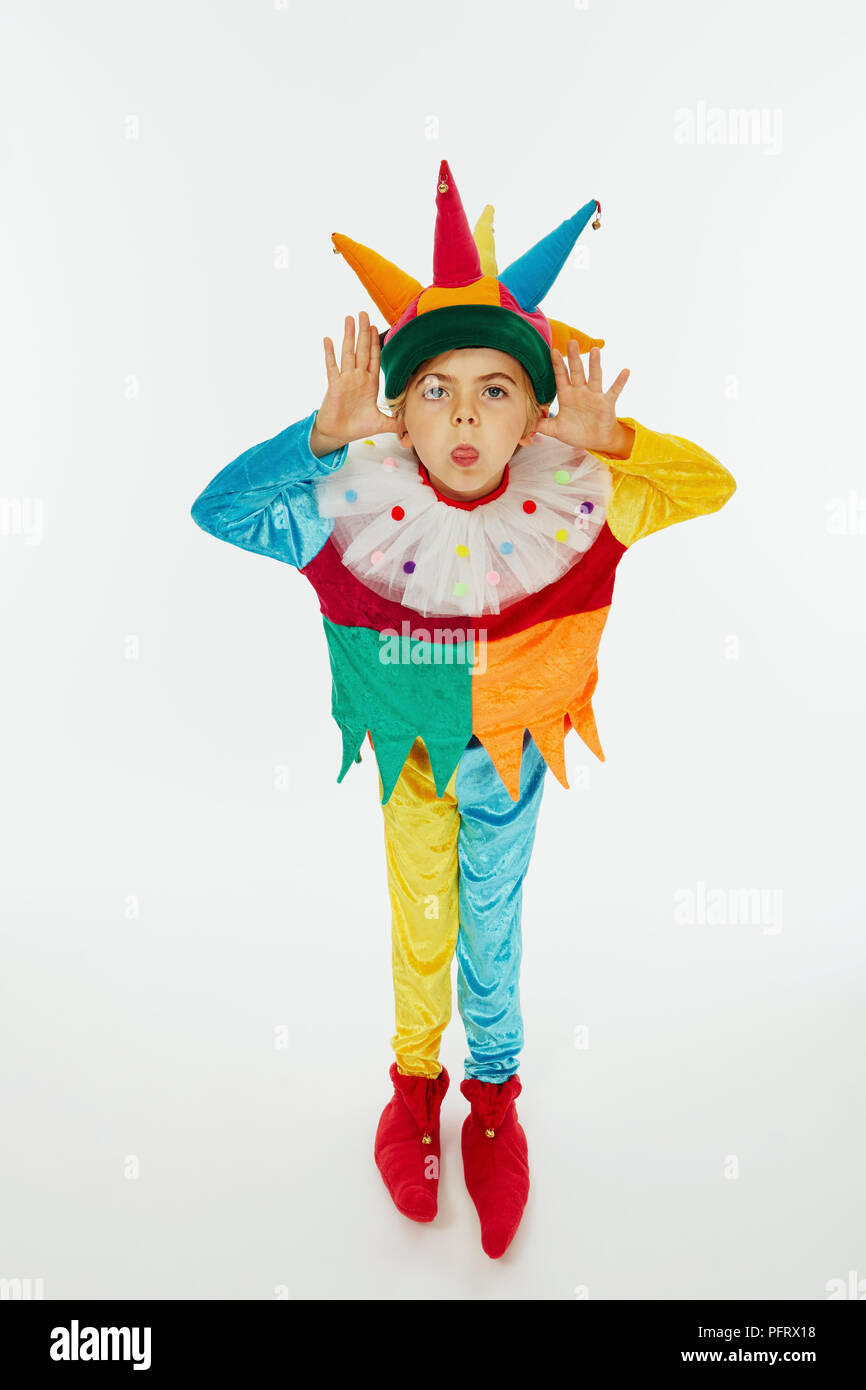 Boy vistiendo coloridos trajes de bufón Foto de stock