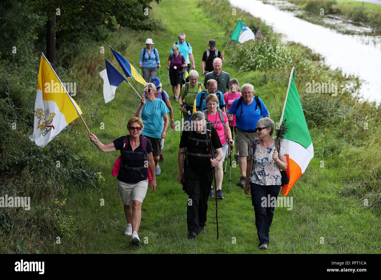 Miembros de Aonach ar Siul (Nenagh Walking Club) a pie del Grand Canal, Ballycommon, Offaly, como parte de sus 220km de caminata de 11 días que culminó en el Phoenix Park en Dublín el domingo coincidiendo con la misa Papal. Foto de stock
