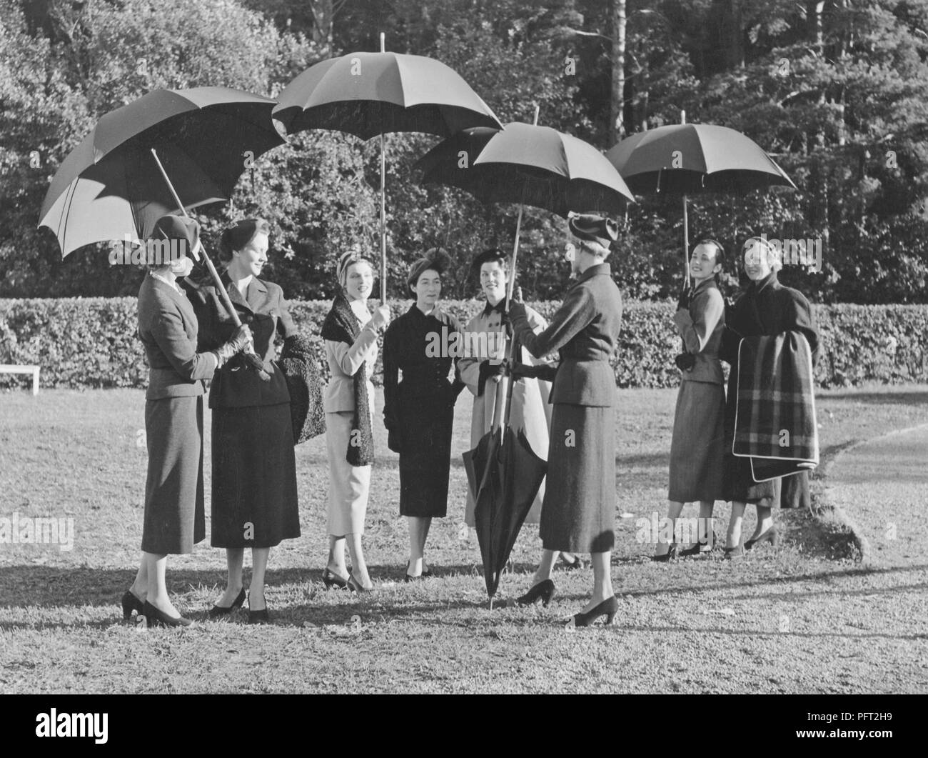 Paraguas en la década de 1950. Un grupo de mujeres vestidas de moda están de pie junto con cuatro sombrillas. Ellos son alumnos de la escuela de moda Märthaskolan en Estocolmo, donde estudian la educación superior dentro de la moda femenina. La escuela es nombrado después de la Princesa Märtha Sueco. Suecia 1954 Foto de stock