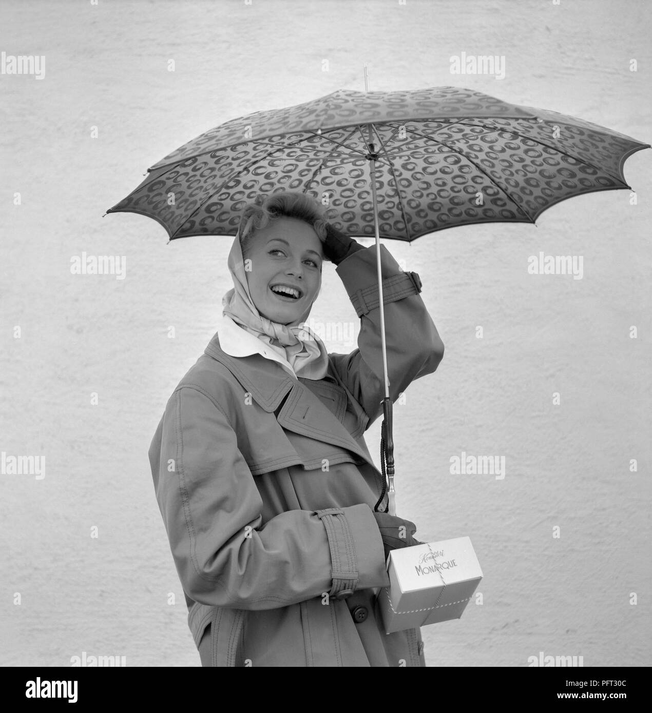 1950 MUJER con sombrilla. Una joven mujer sosteniendo un paraguas en un día lluvioso. Suecia 1955 Foto de stock