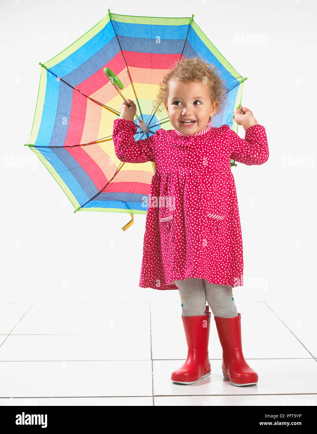 Niña pequeña (2 años) vistiendo botas Wellington y celebración de paraguas  Fotografía de stock - Alamy