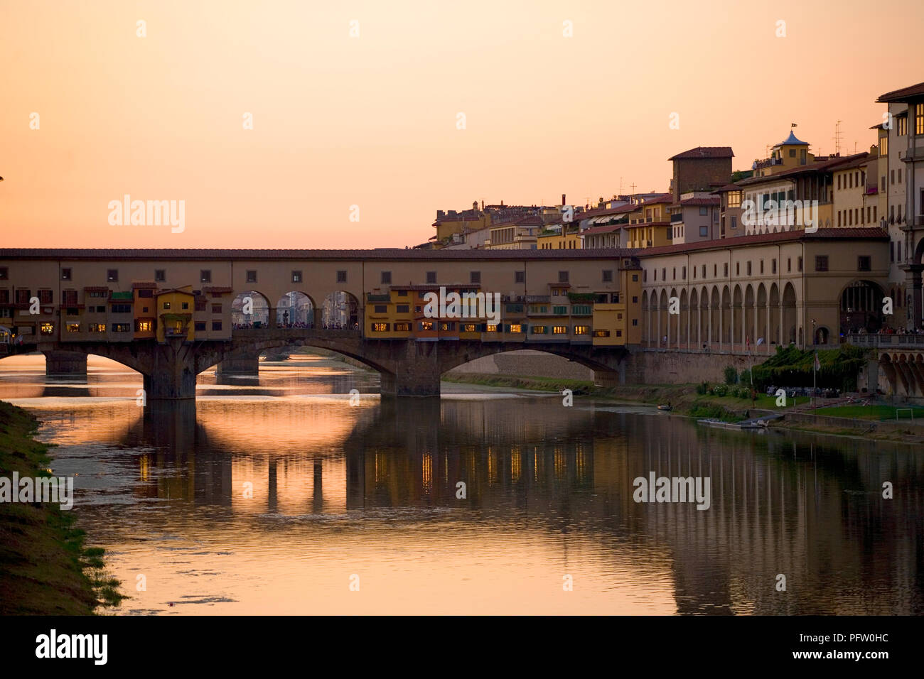 Atardecer sobre el río Arno en Florencia, Toscana, Italia, con el Ponte Vecchio que abarca el río: desde el Ponte alle Grazie Foto de stock