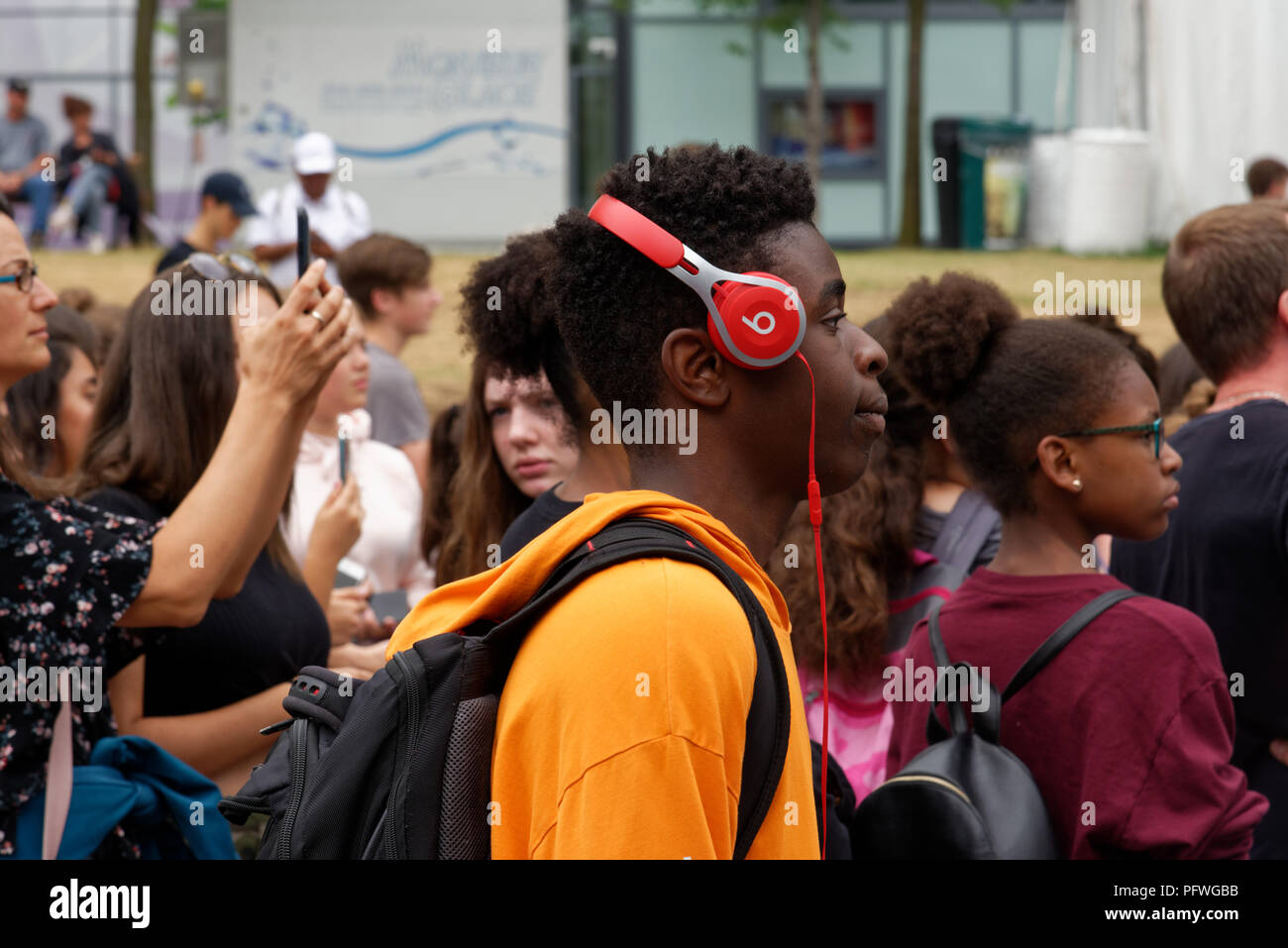 Un joven negro usando auriculares Beats en una multitud Foto de stock