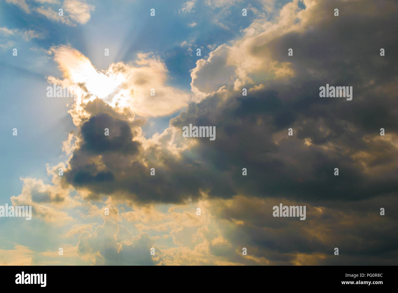 El sol brillante iluminando las nubes desde atrás con rayos de luz Foto de stock