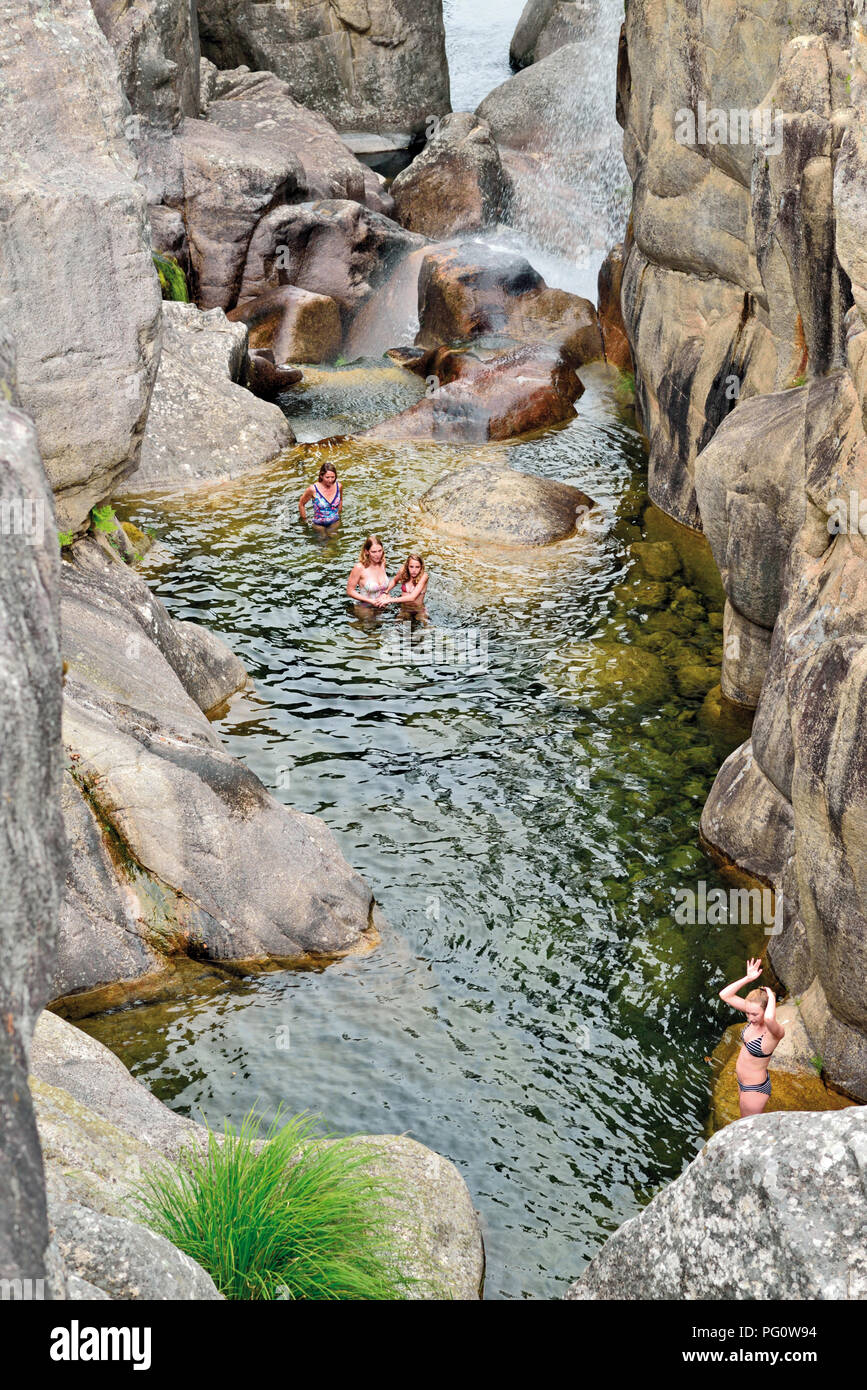 Cuatro niñas en una refrescante piscina natural del río salvaje en un cañón rocoso Foto de stock