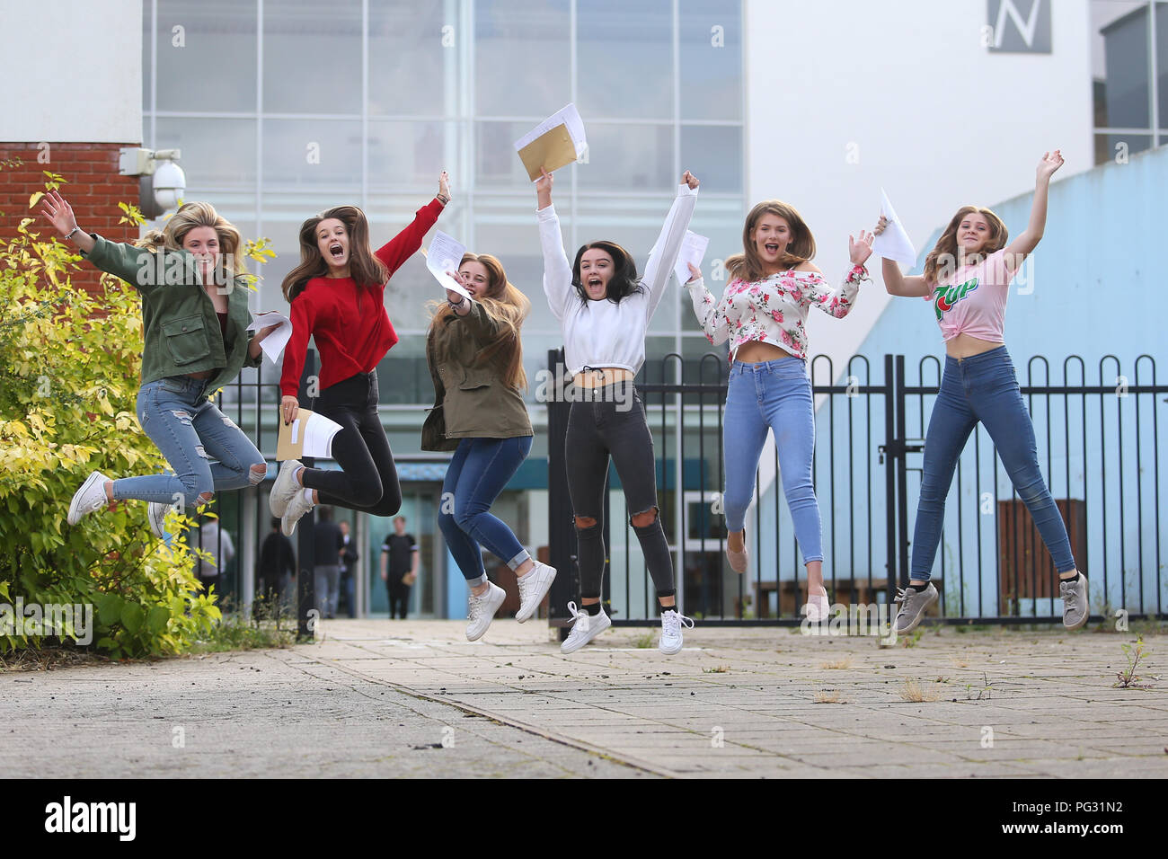 Bromsgrove, Worcestershire, Reino Unido. 23 Aug, 2018. Los alumnos saltar de alegría después de la apertura de sus resultados de exámenes de la Escuela Secundaria en el norte de Bromsgrove, Worcestershire, Reino Unido. Alrededor de 590.000 alumnos de 4.000 escuelas secundarias de toda Gran Bretaña son el primer año grupo adopte la nueva gcse creado por el ex secretario de Educación, Michael Gove, como parte de un intento de fomentar el rigor en el GCSE así como disponer de cursos evaluación disminuir en favor de los exámenes. Crédito: Peter Lopeman/Alamy Live News Foto de stock
