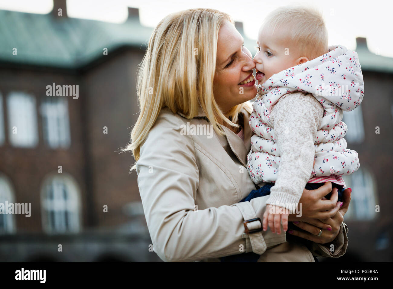 La madre y el bebé feliz besos, riendo y abrazando en la naturaleza al aire libre Foto de stock