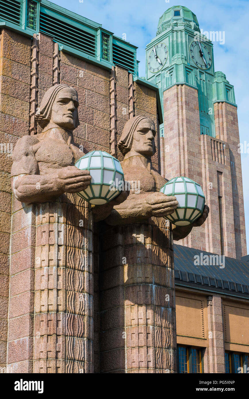 Helsinki art nouveau, vista de dos enormes estatuas de granito (los hombres de piedra) con luces de globo situado en la entrada de la estación de tren de Helsinki, Finlandia Foto de stock