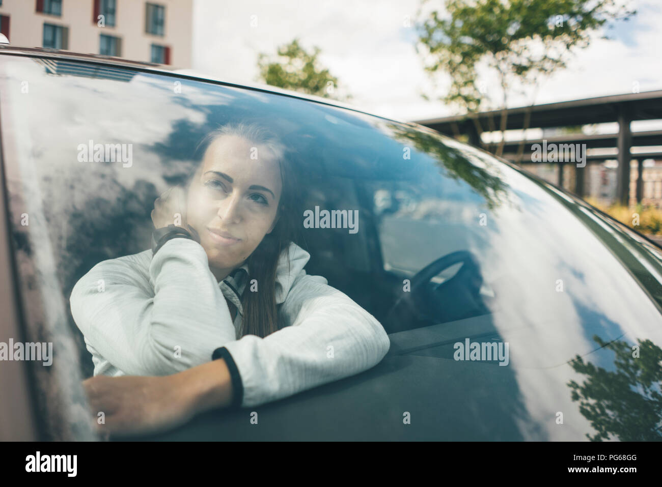 Sportive joven en coche mirando hacia afuera de la ventana Foto de stock