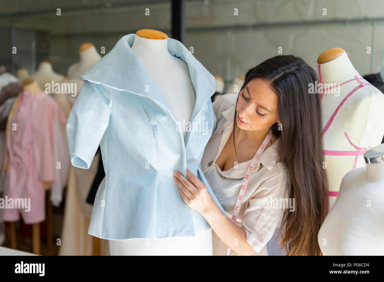 Joven diseñador de moda ropa de montaje sobre el modelo de modista  Fotografía de stock - Alamy