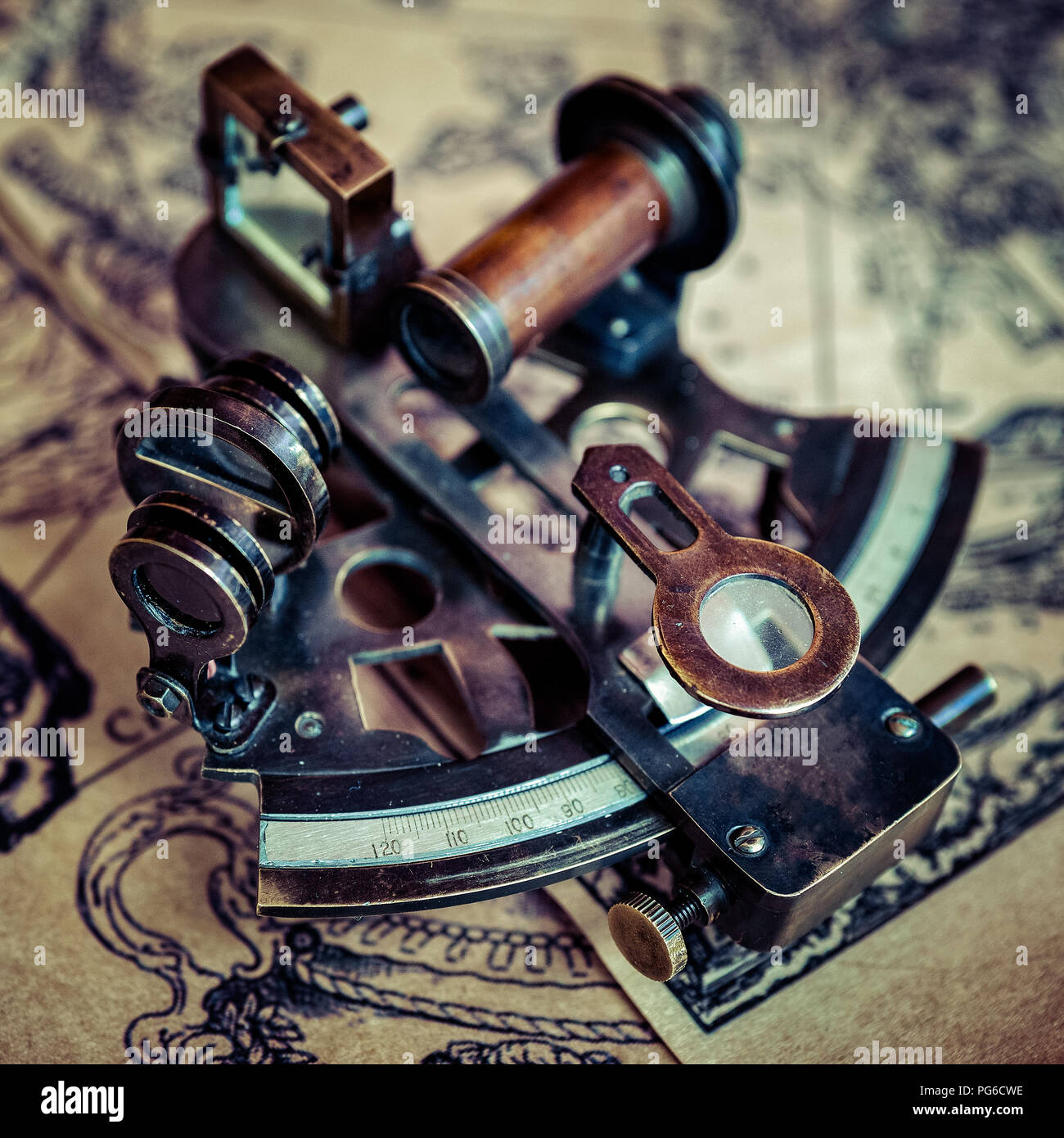 Hermoso vintage sextante marino o índice de dispositivo óptico descansa sobre una mesa cubierta con antiguos mapas náuticos. Los viajes marítimos, ubicación, posicionamiento th Foto de stock
