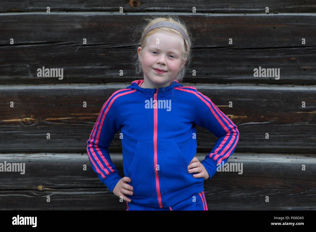 Retrato de una niña de aldea cerca de una antigua casa de madera Foto de stock