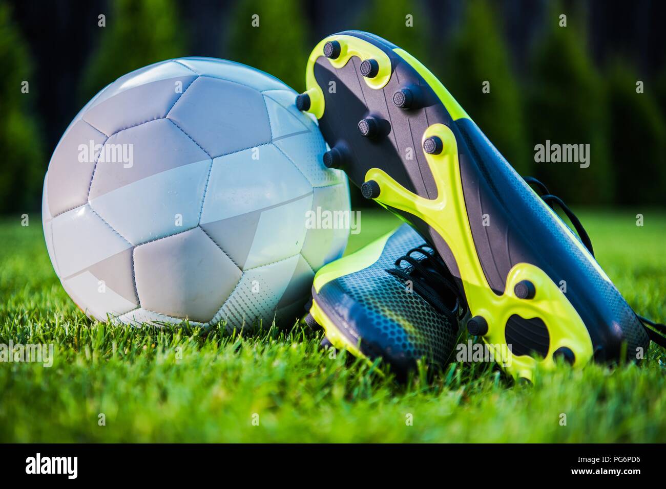 Torneo de Fútbol Moderno concepto con una pelota de fútbol y jugador de los tacos de los zapatos. Tema de deportes de equipo. Foto de stock