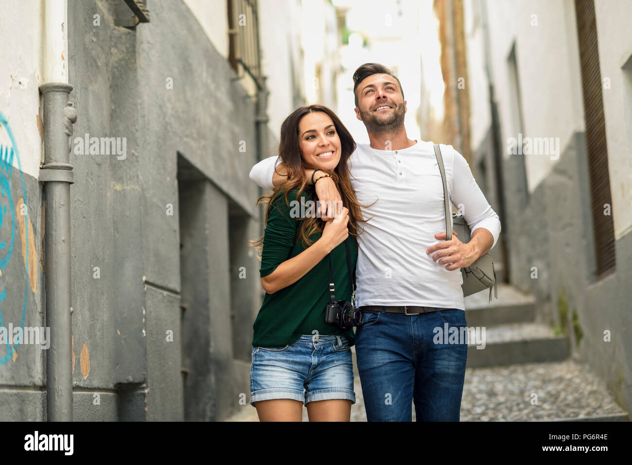 Feliz pareja de turistas caminando por la ciudad Foto de stock