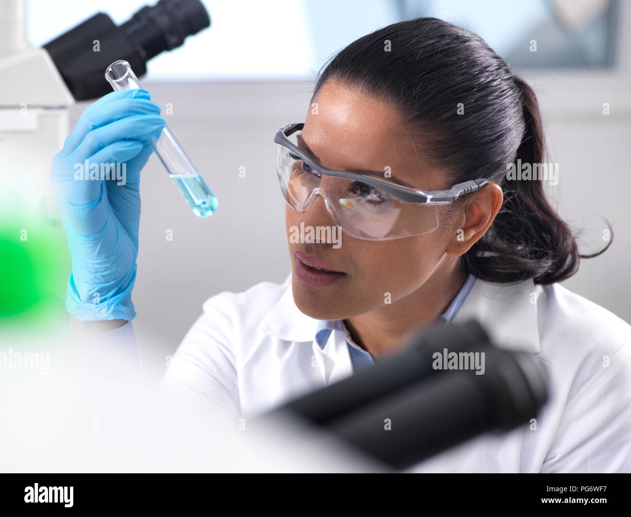 La investigación en biotecnología, investigadora mezcla una fórmula química Foto de stock