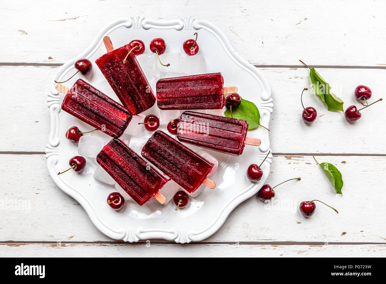 Caseros caramelos de cereza de hielo, cubitos de hielo y las cerezas en la placa Foto de stock