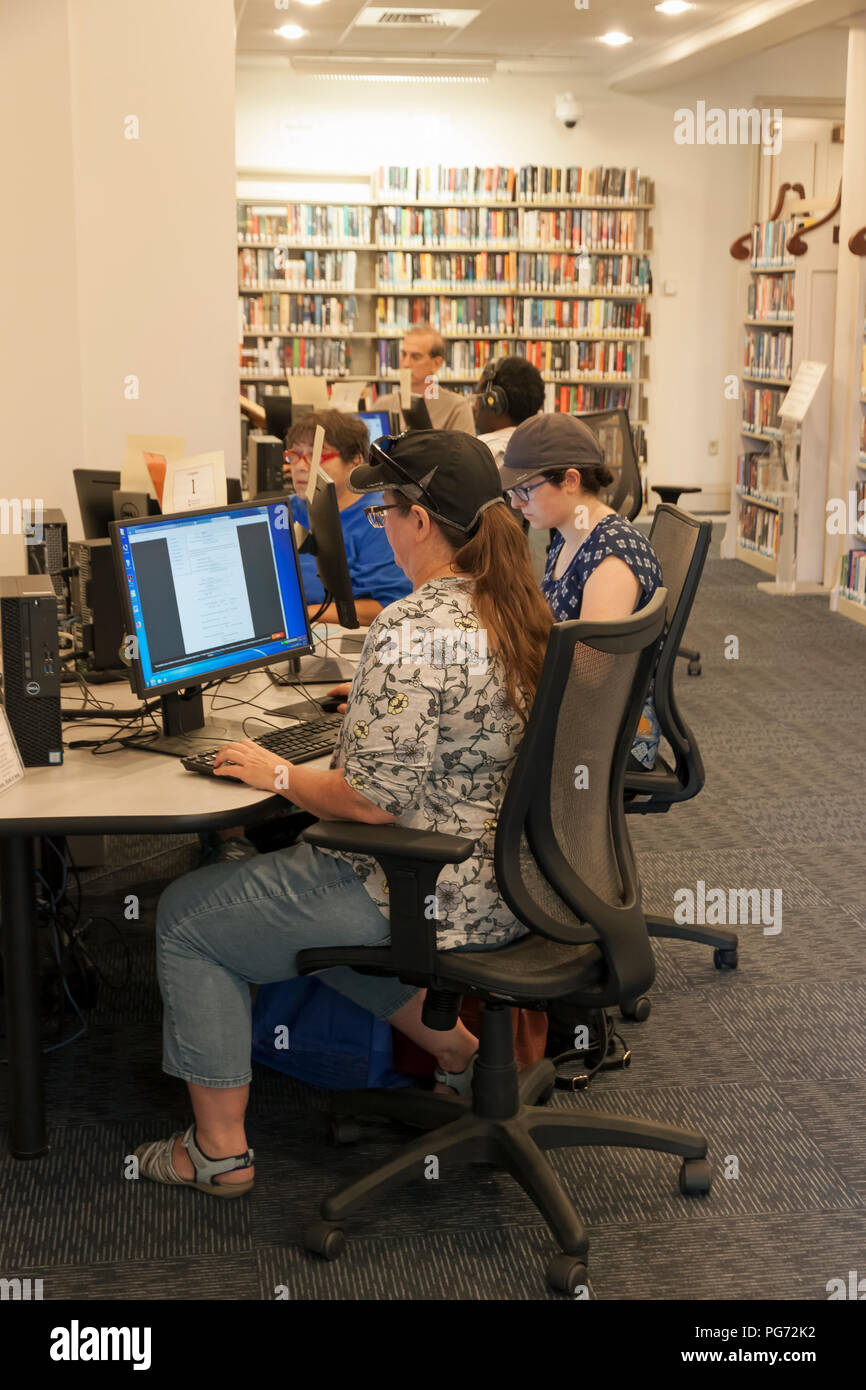 Los adultos usan ordenadores en una biblioteca pública. Foto de stock