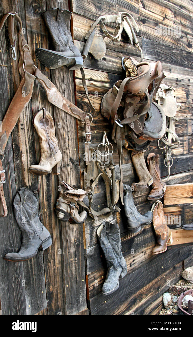 Soportó la pared de madera rústica botas occidental monturas Foto de stock