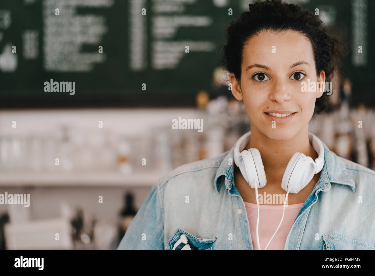 Mujer joven con auriculares, trabajan en espacio de coworking Foto de stock