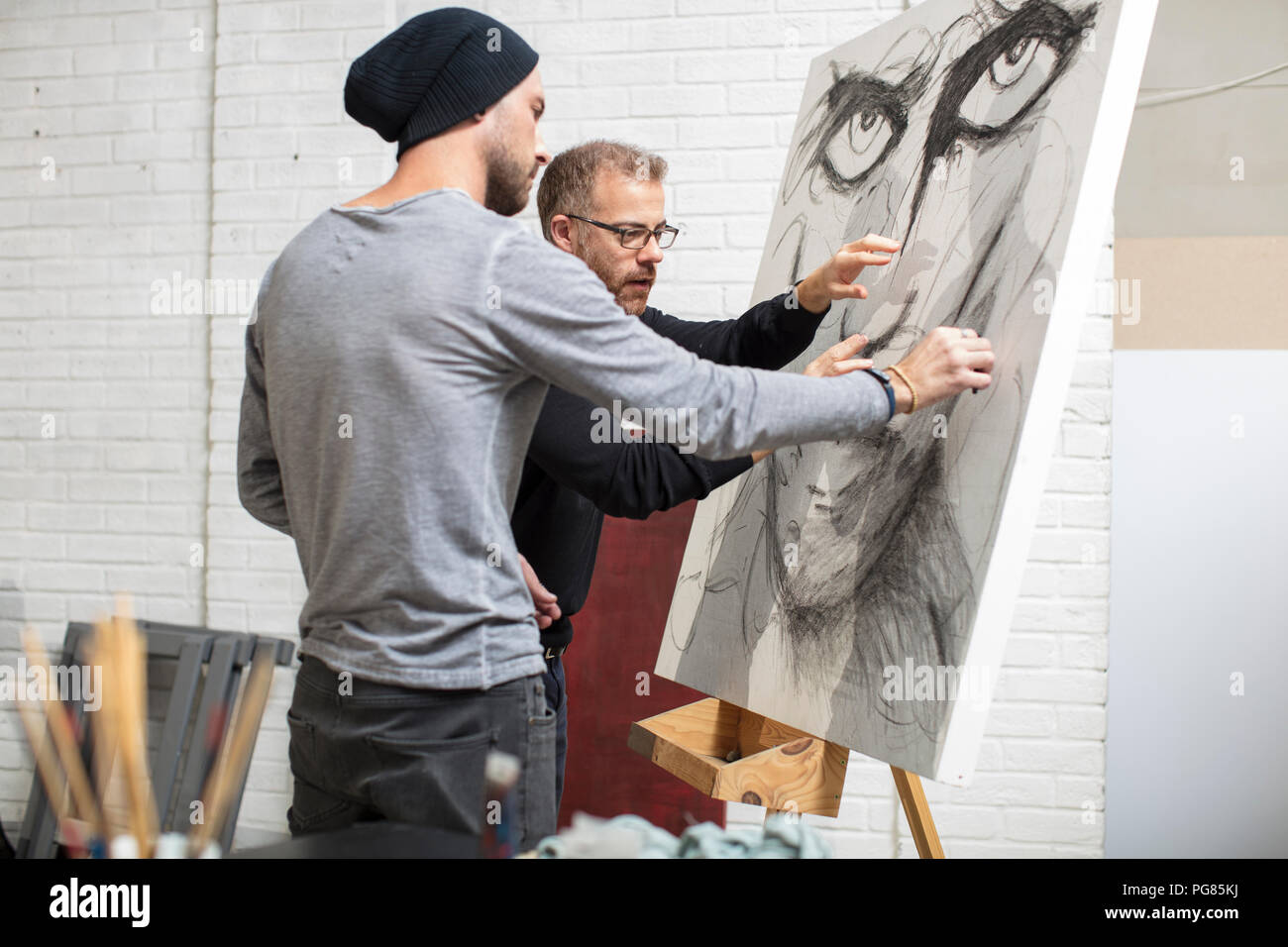 Hablando de dibujo del artista con el hombre en studio Foto de stock