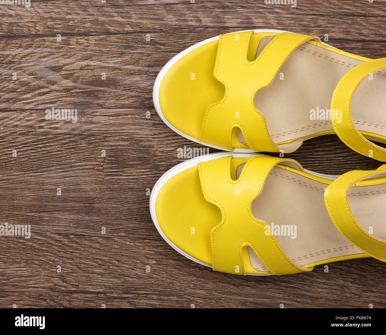 Sandalias de cuña de color amarillo en la superficie de madera oscura.  Zapatos de verano para la mujer. Vista superior, espacio de copia  Fotografía de stock - Alamy