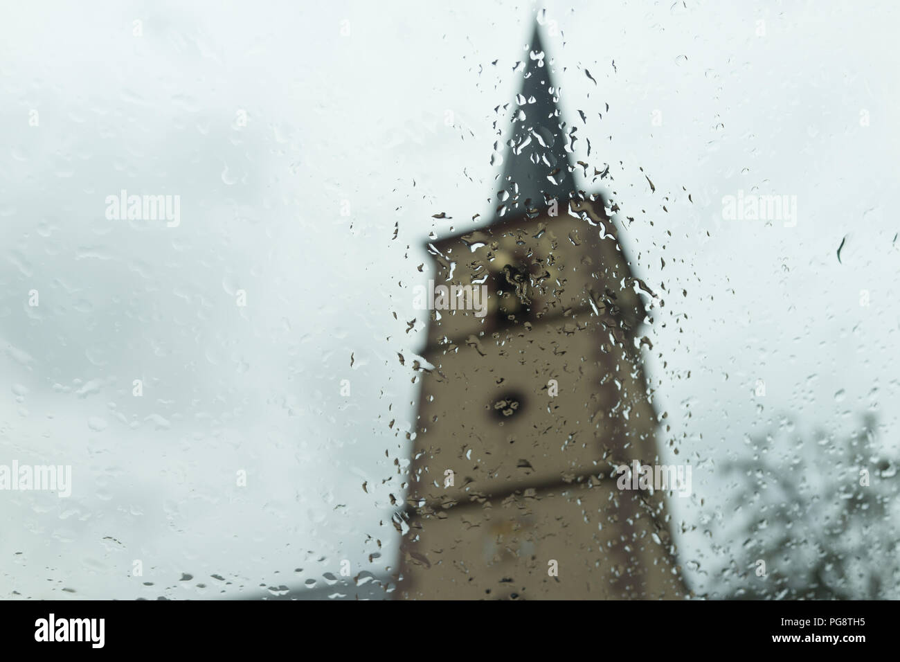 Oberschwarzach Baviera Alemania, Sábado 25 de agosto de 2018 / dramáticos cambios meteorológicos a finales del verano. El seco y caluroso verano europeo se convierte en una fría y lluviosa pre otoño. La torre de la iglesia en el fondo se ve empañada por el inicio de la fría mañana de lluvia. Crédito: Ingo Menhard/Alamy Live News Foto de stock