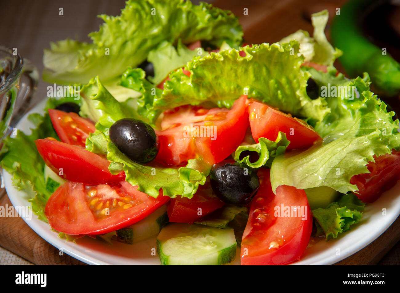 Plato con ensalada de tomates, pepinos y aceitunas con aceite de oliva Foto de stock