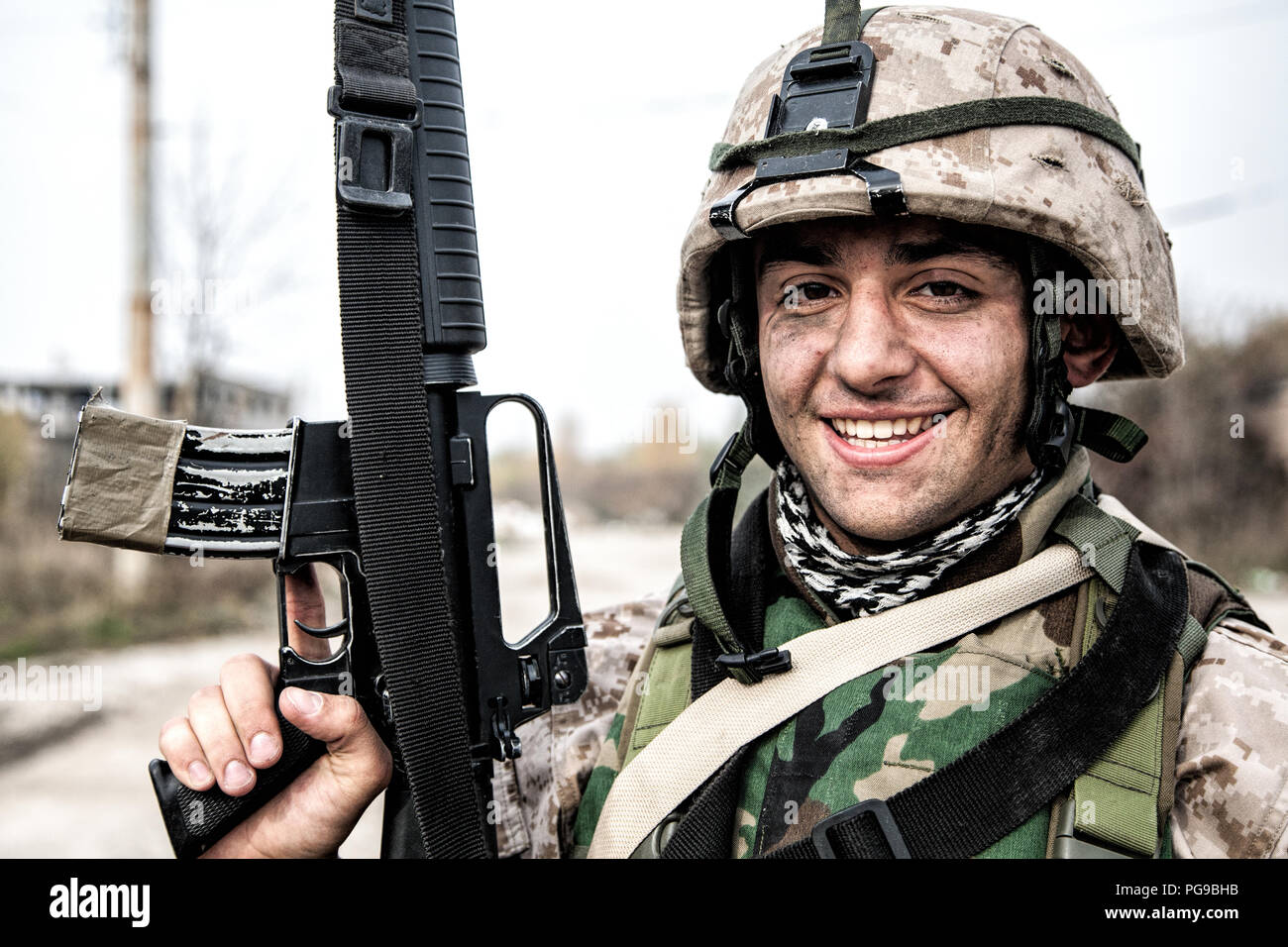 Sonriente soldado del ejército, la Infantería de Marina de los Estados  Unidos shooter de infantería en uniforme de combate de camuflaje,  protegidos con chalecos antibalas y cascos, posando con asalto ri Fotografía