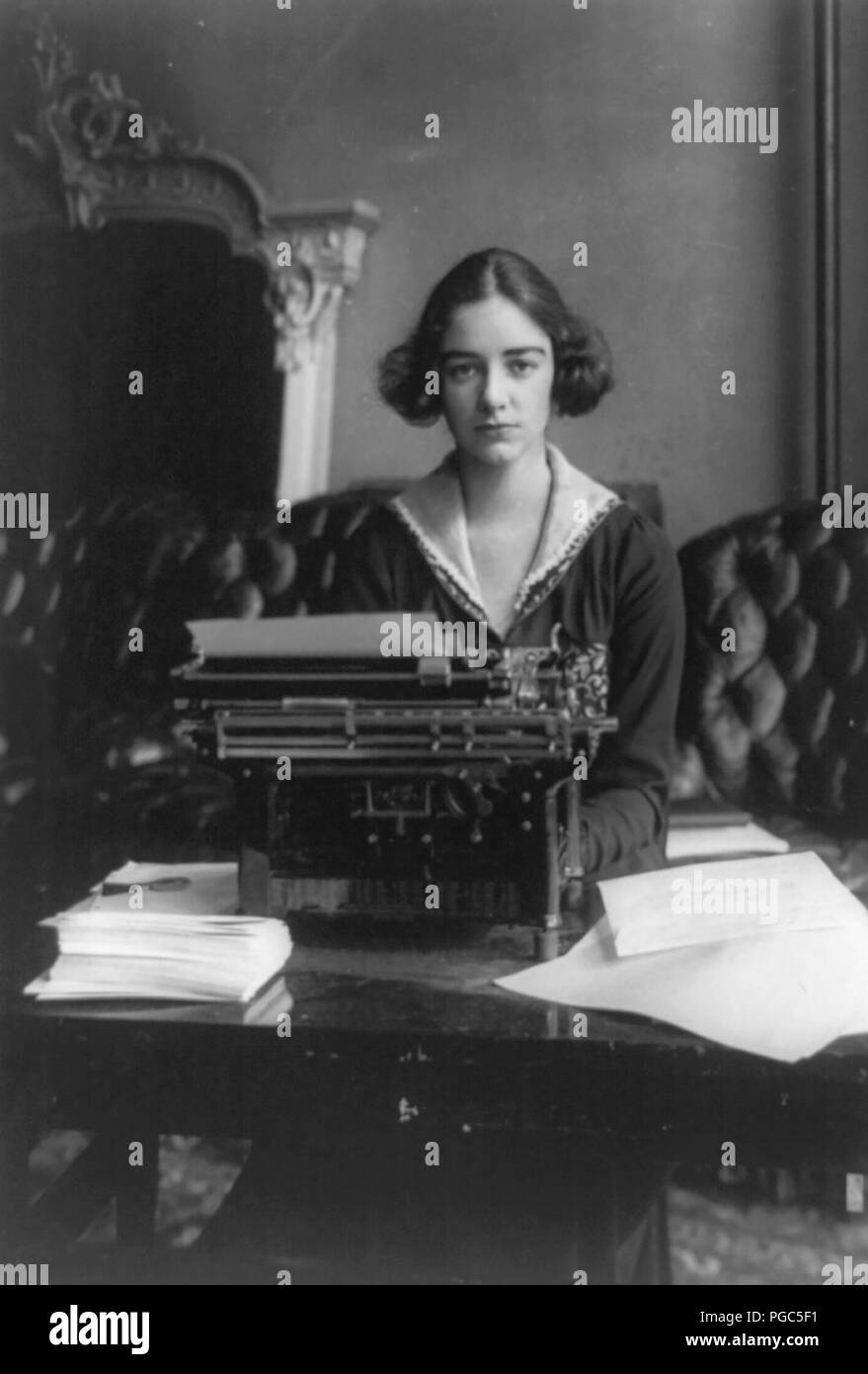 Flora Payne Whitney Miller, tres cuartos de longitud vertical, sentado en máquina de escribir, frente a frente, circa 1919 Foto de stock