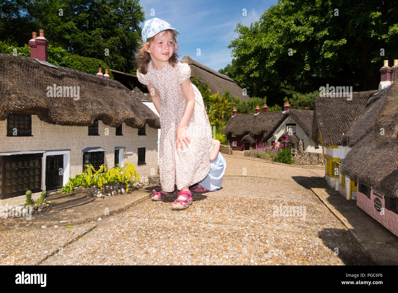 Niña / niña / niño / Niños / niño / niños explorar la aldea modelo en Godshill en la Isla de Wight, en un día soleado con el cielo azul / cielos. Reino Unido (101 Foto de stock