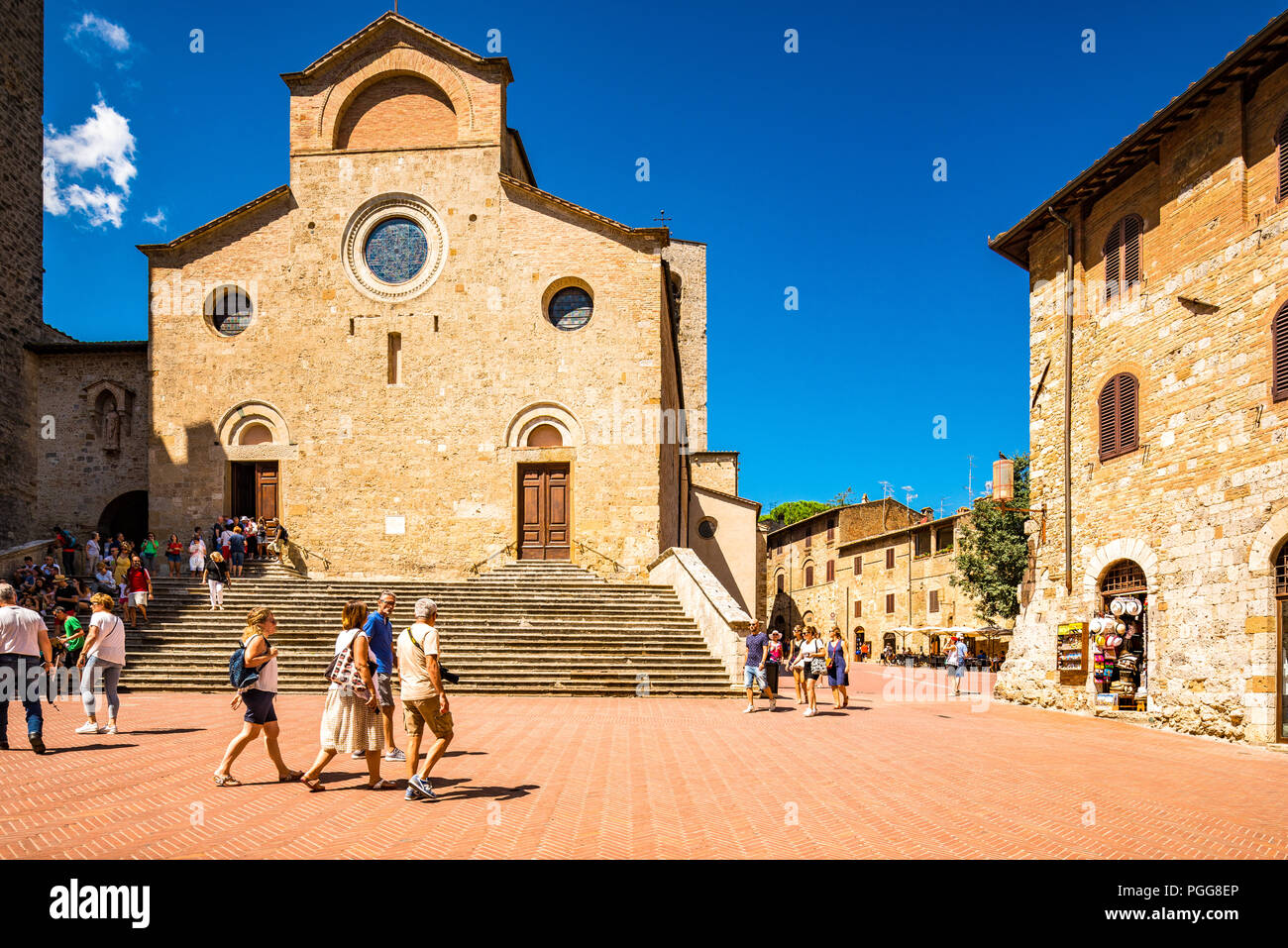 La iglesia románica de Santa Maria Assunta, o Duomo di San Gimignano y frente a la Piazza del Duomo en San Gimignano, Italia Foto de stock
